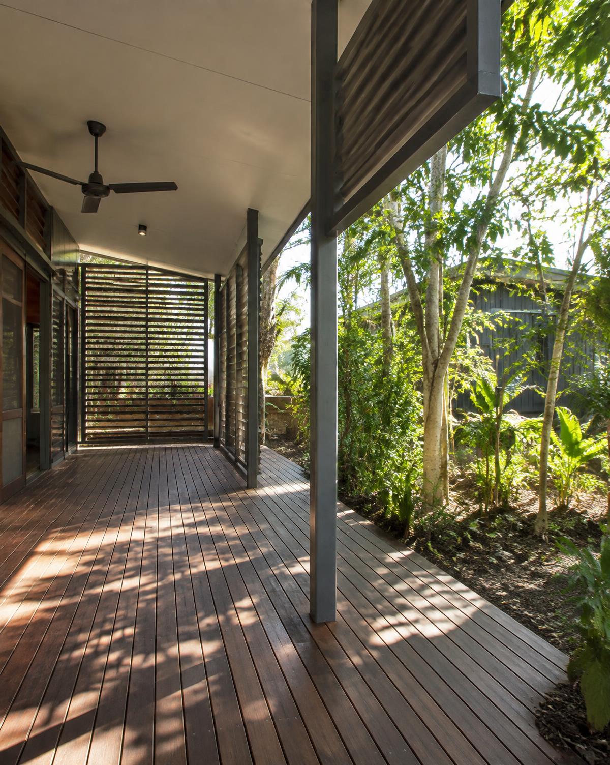 Hardwood verandah with steel posts and louvred screens surrounded by tropical planting